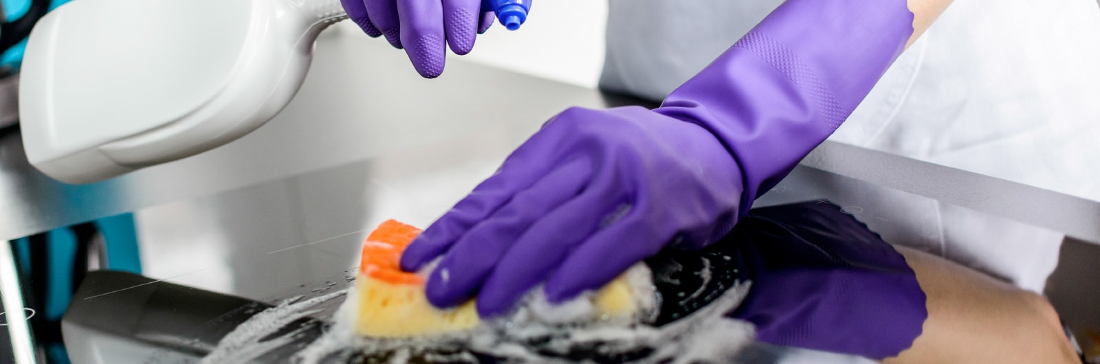 A cleaner scrubbing an oven