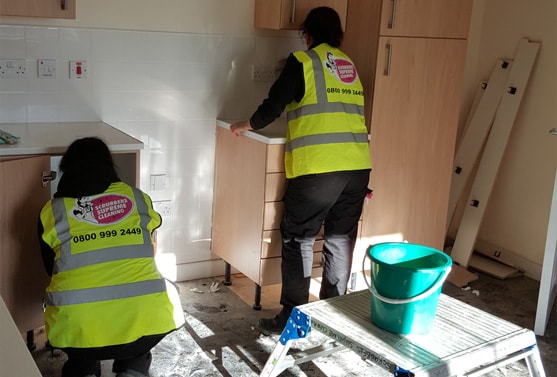 2 women cleaning kitchen units
