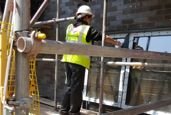 Woman cleaning windows on scaffholding