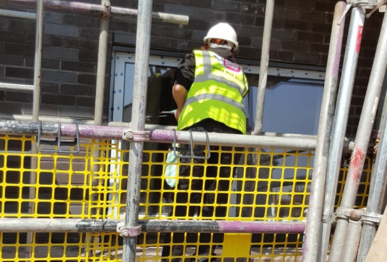 Woman cleaning windows on scaffholding